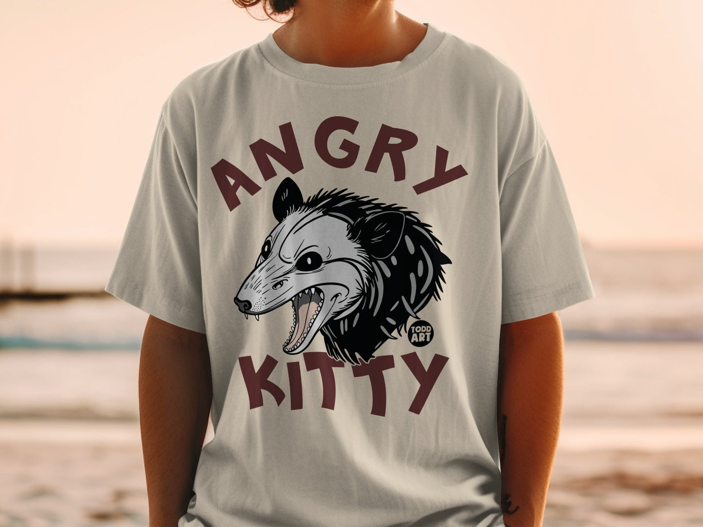 T-shirt with "Angry Kitty" text and a cartoon opossum graphic.