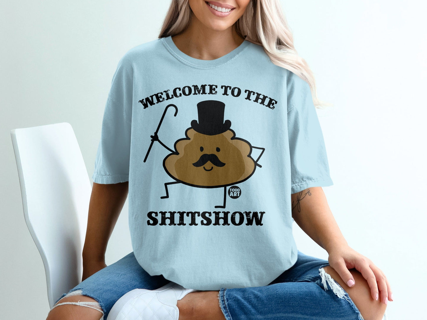 Light blue t-shirt with "WELCOME TO THE SHITSHOW" and a cartoon poop character.