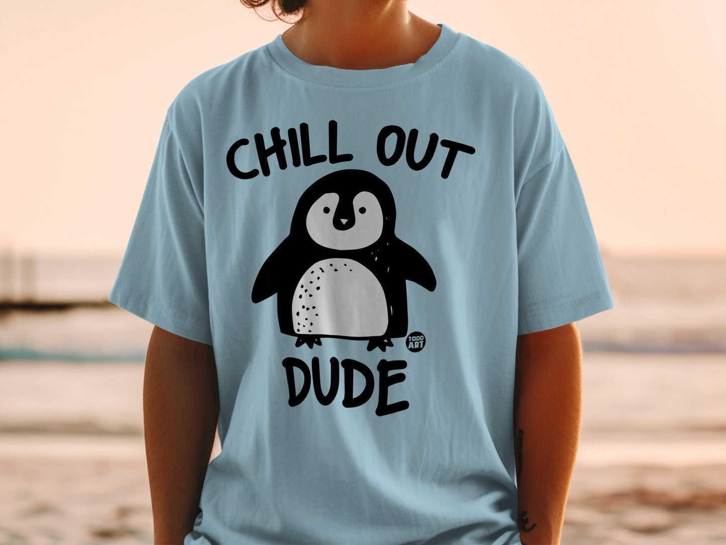 Light blue t-shirt with a cartoon penguin and "CHILL OUT DUDE" text.