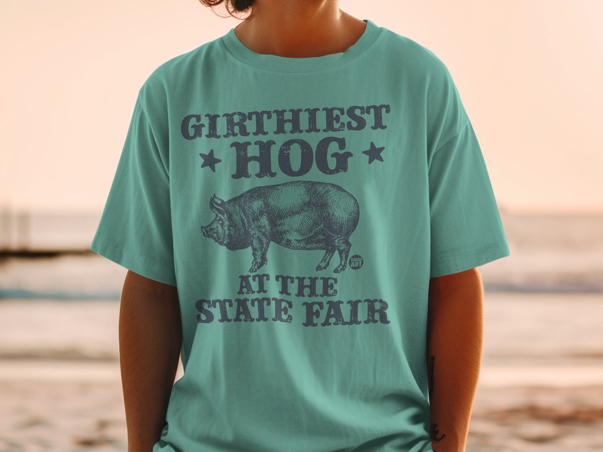 T-shirt with "GIRTHIEST HOG AT THE STATE FAIR" text and pig graphic.