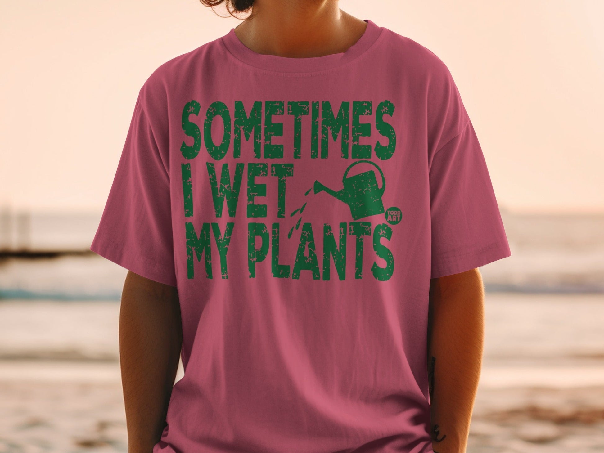 T-shirt with green text "SOMETIMES I WET MY PLANTS" and a watering can.