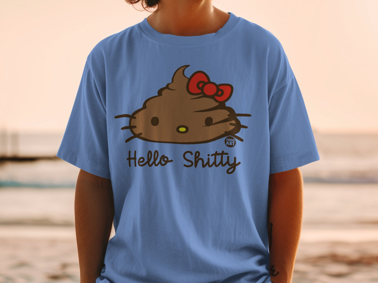 Blue t-shirt featuring a brown Hello Kitty-style character with a red bow and text that says "Hello Shitty".