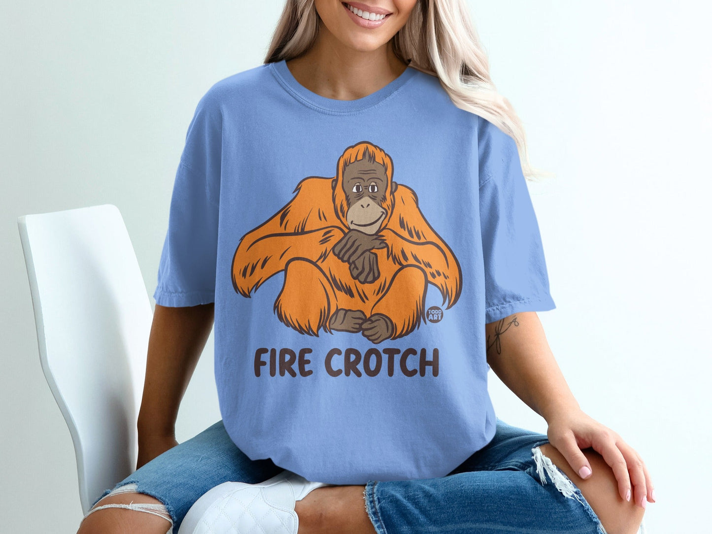 Light blue t-shirt with an orange orangutan graphic and "FIRE CROTCH" text.