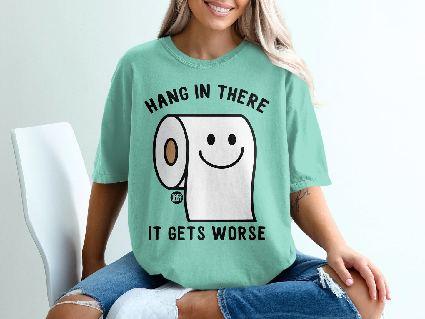 Mint t-shirt with smiling toilet paper saying "Hang in there it gets worse."