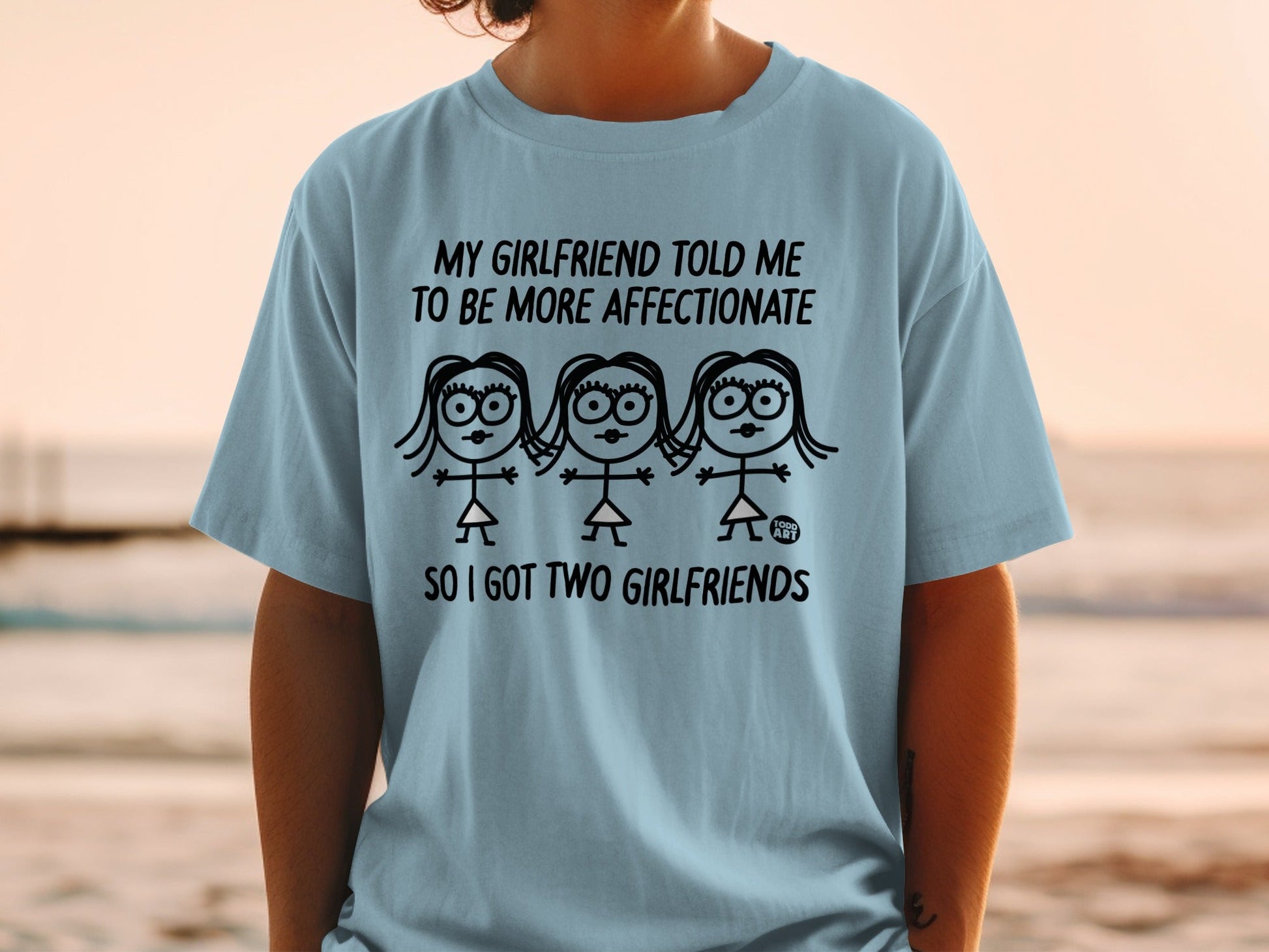 Light blue t-shirt with text "My girlfriend told me to be more affectionate so I got two girlfriends".