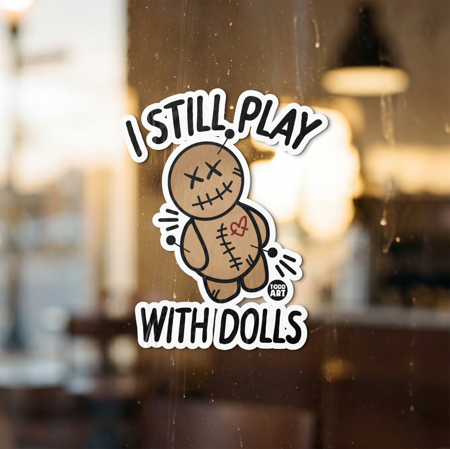 Sticker with voodoo doll and text "I STILL PLAY WITH DOLLS".