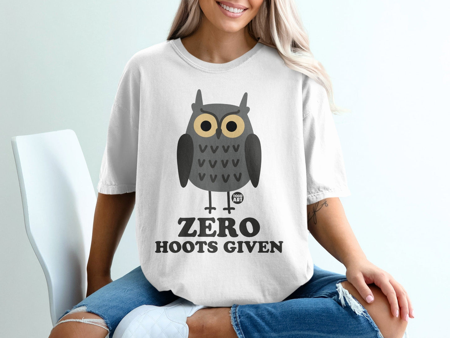 White t-shirt with a cartoon owl graphic and "ZERO HOOTS GIVEN" text.