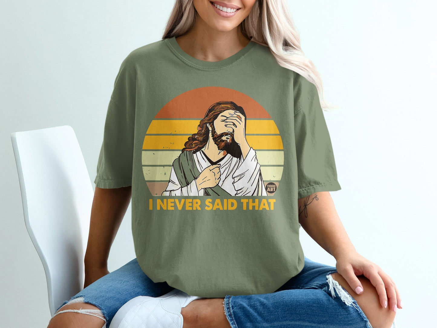 Olive green t-shirt with "I NEVER SAID THAT" text and Jesus graphic.