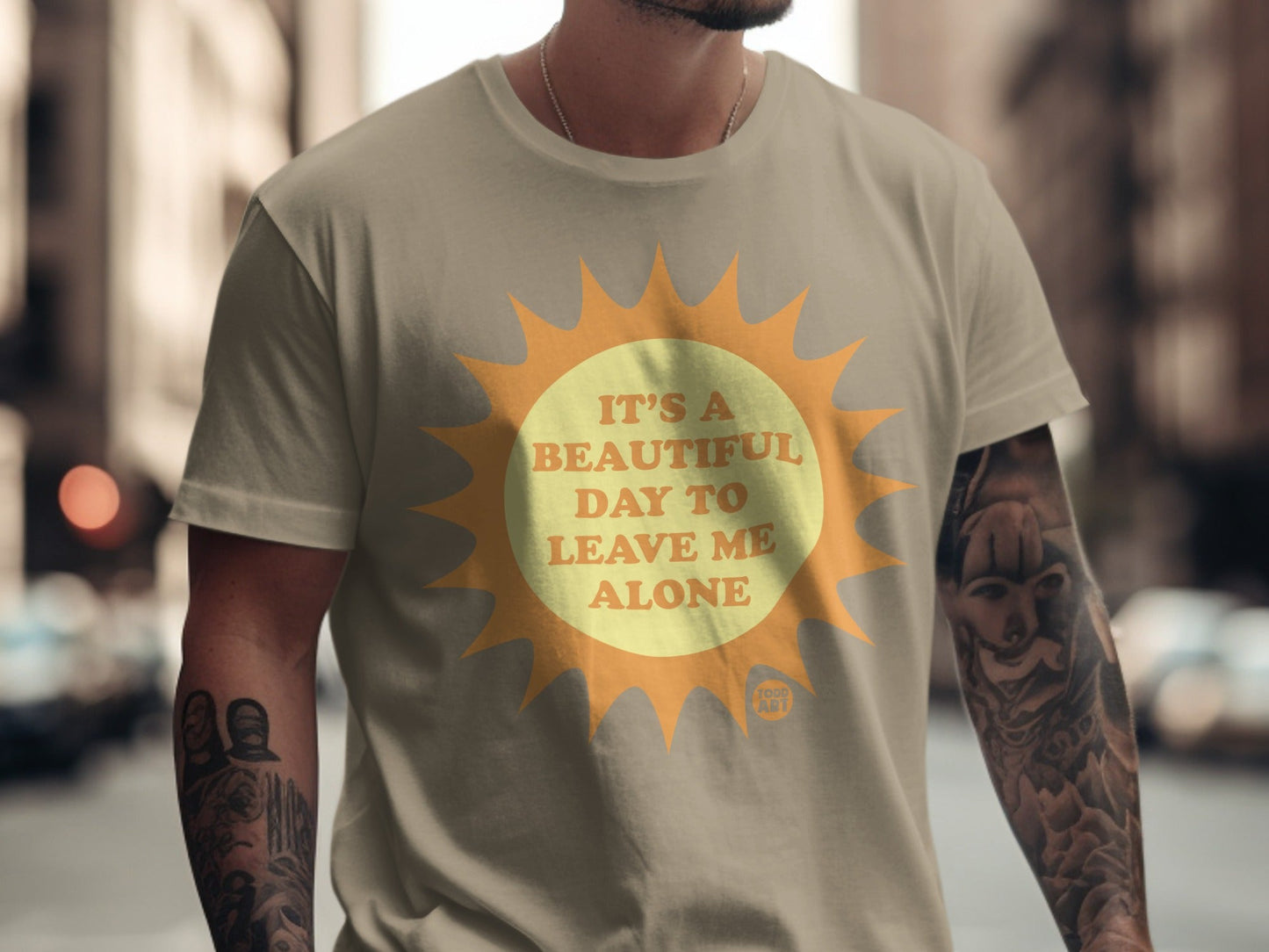 Tan t-shirt with a sun graphic and text "It's a beautiful day to leave me alone."
