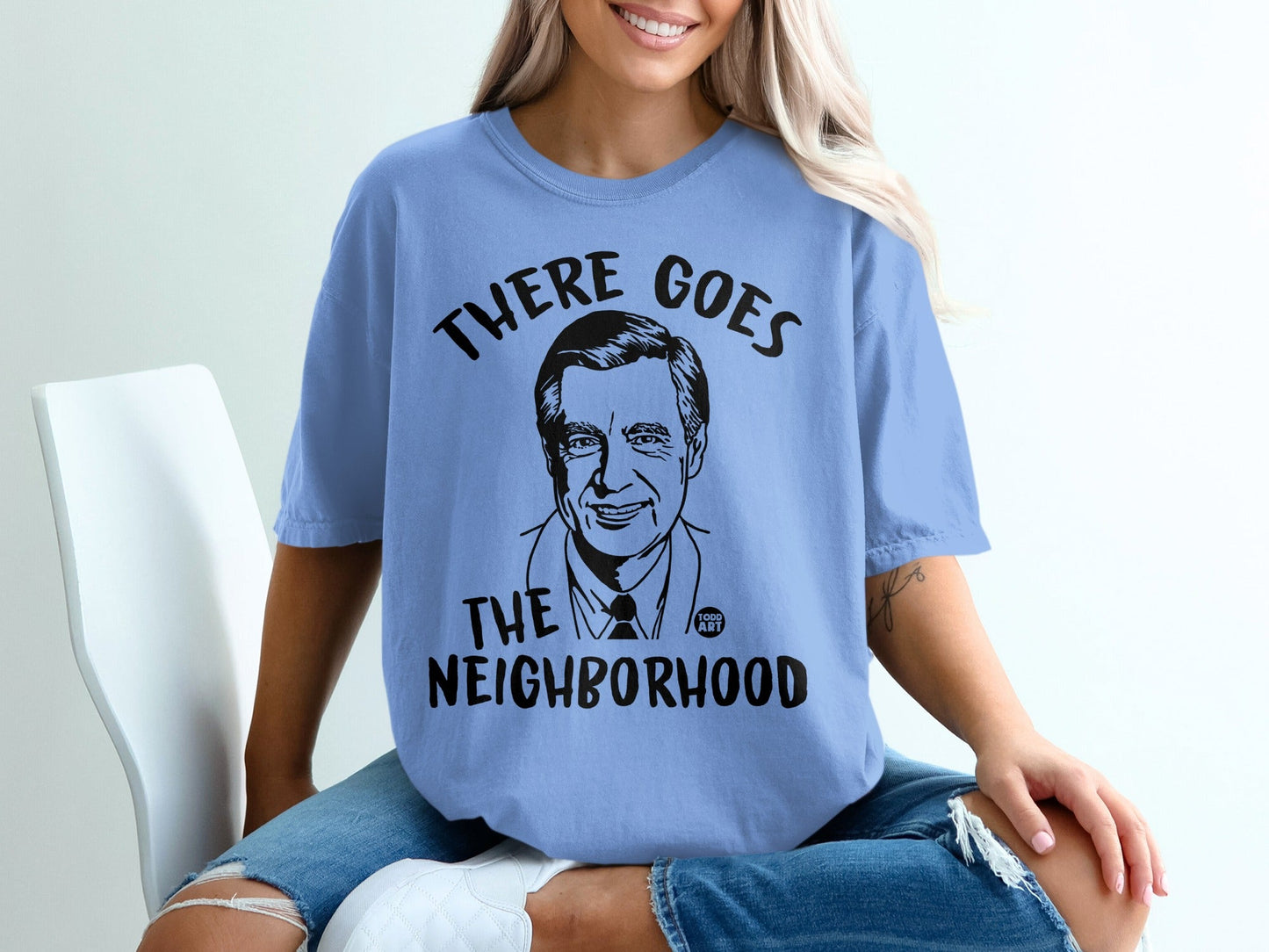 Blue t-shirt with a black graphic of Fred Rogers and text "THERE GOES THE NEIGHBORHOOD".
