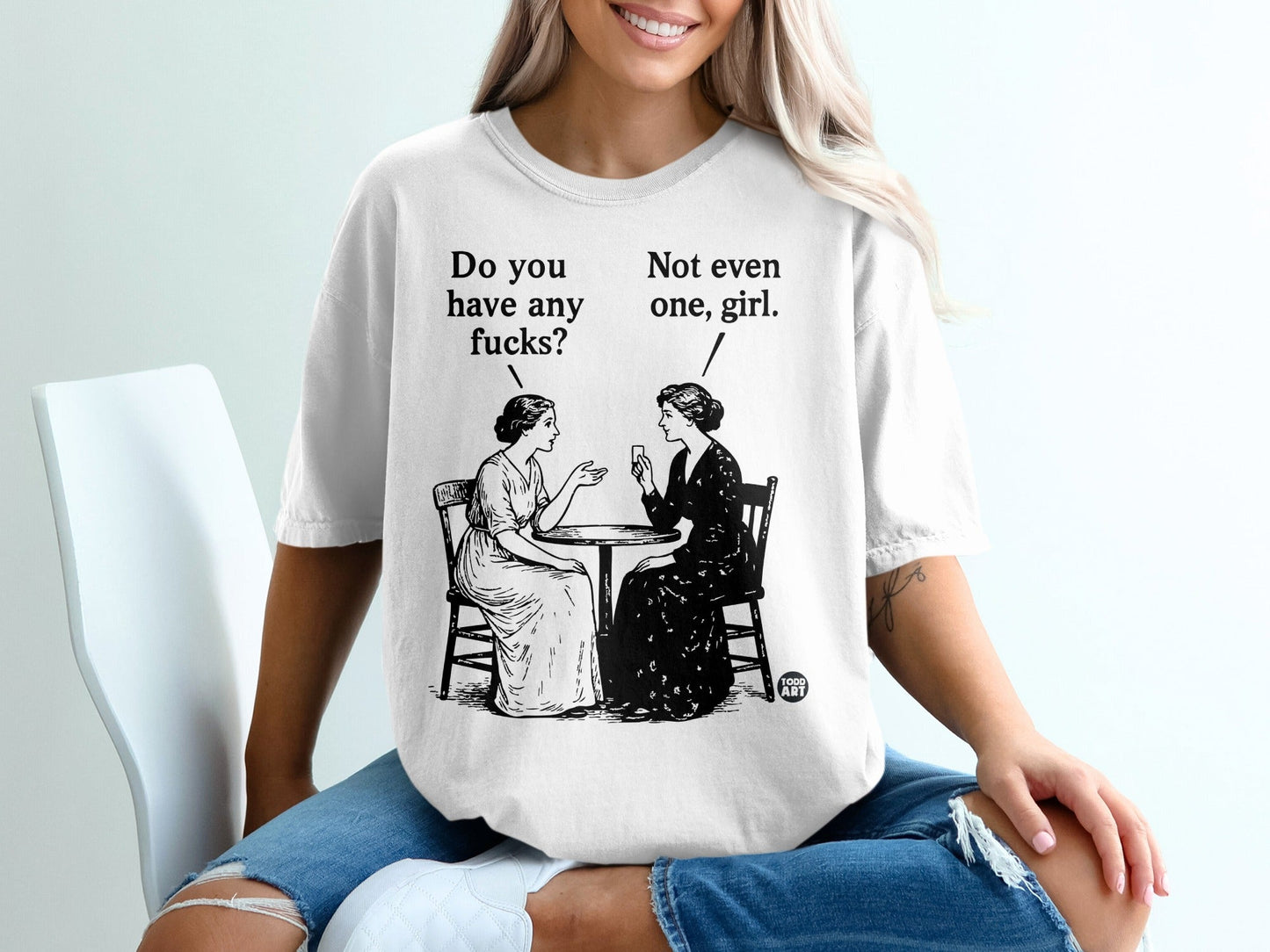 T-shirt with illustration of two women talking, one asks "Do you have any fucks?", the other replies "Not even one, girl."