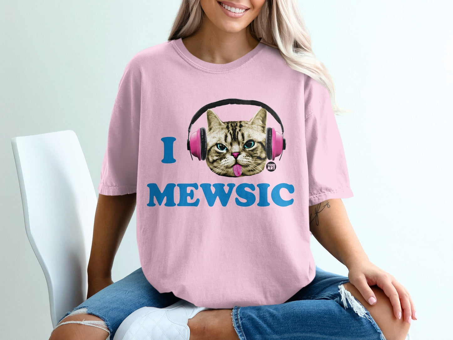 Pink t-shirt with "I MEWSIC" text and headphones on a cat graphic.