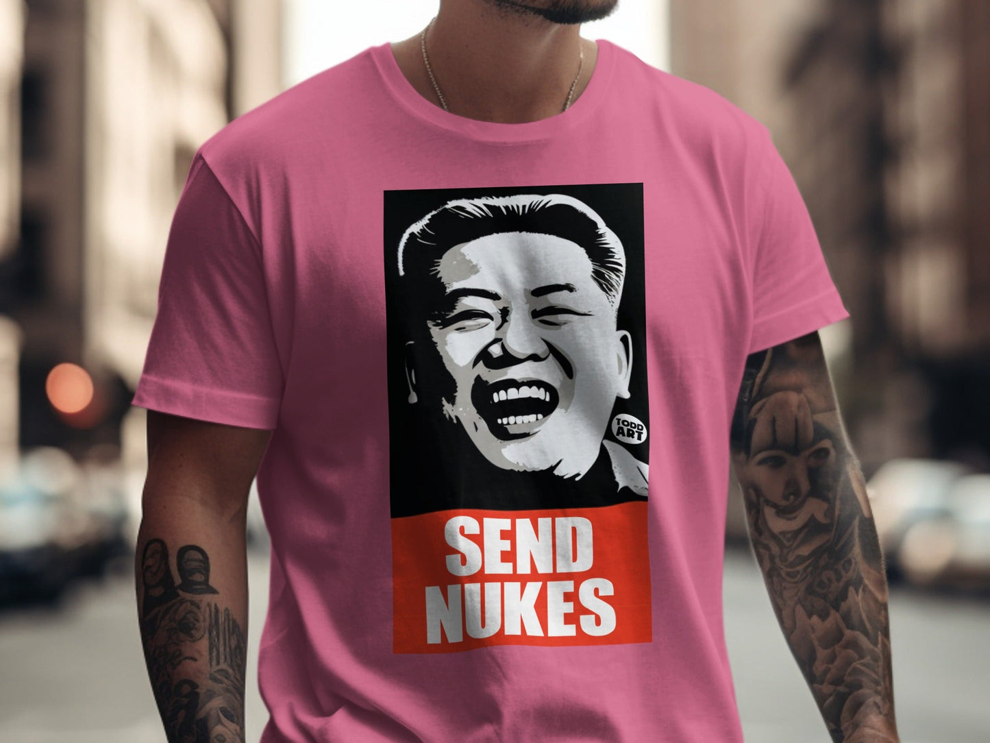 Pink t-shirt with a graphic of Kim Jong Un and the words "SEND NUKES".