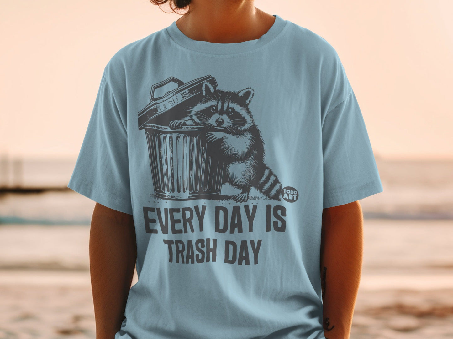 T-shirt with raccoon in trash can graphic and text "Every Day Is Trash Day".