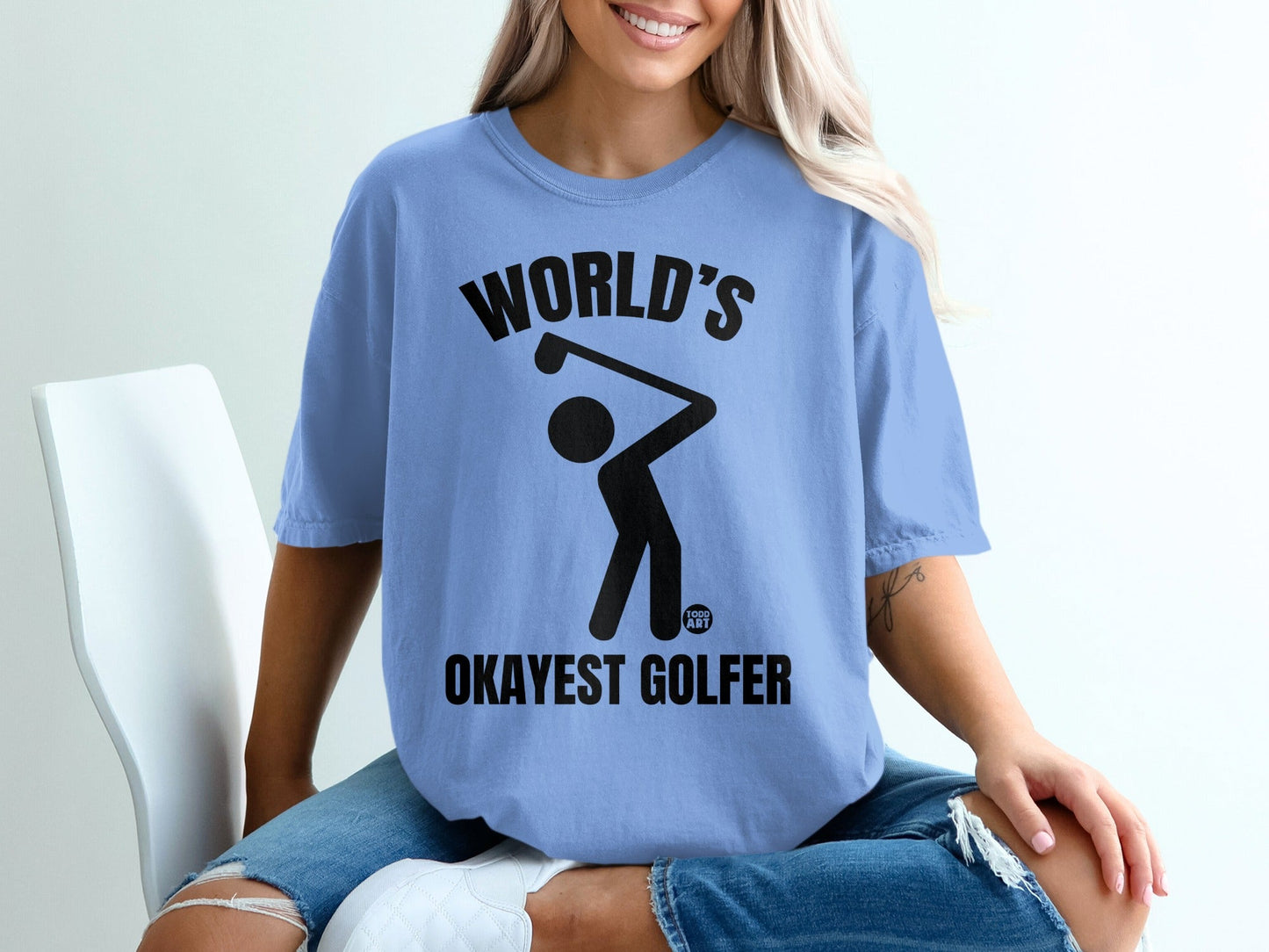 Blue t-shirt with "WORLD'S OKAYEST GOLFER" text and golfer graphic.