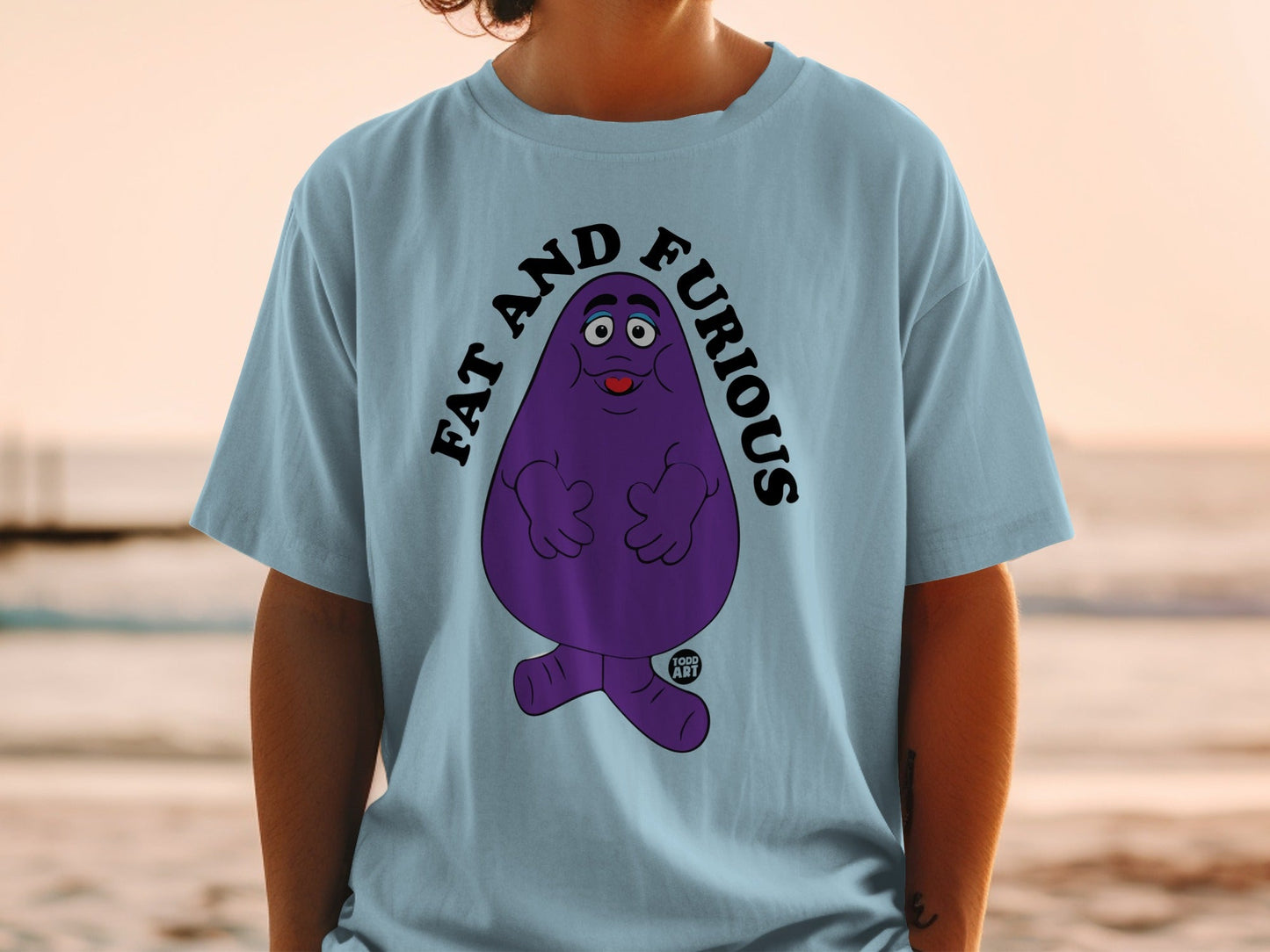 Light blue t-shirt with a cartoon purple character and "FAT AND FURIOUS" text.