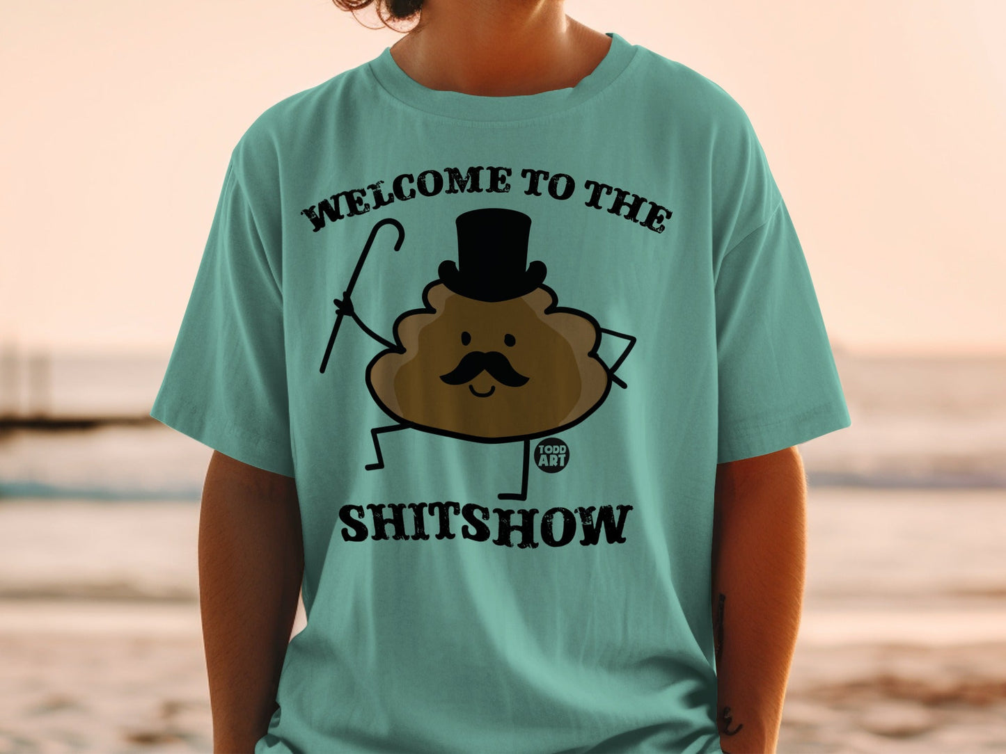 T-shirt with "Welcome to the Shitshow" and a smiling poop character wearing a top hat.
