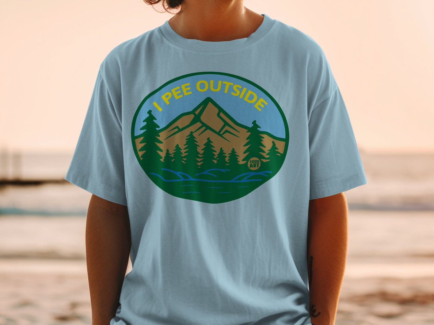 T-shirt with mountains, trees, and lake graphic, reading "I pee outside."