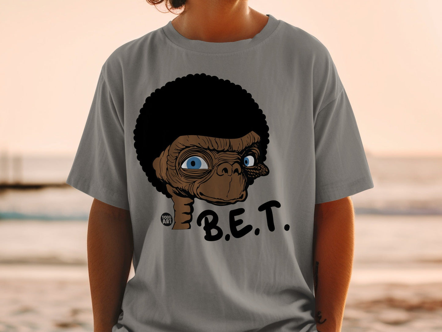 T-shirt featuring a stylized ET character with an afro, blue eyes, and "B.E.T." text.