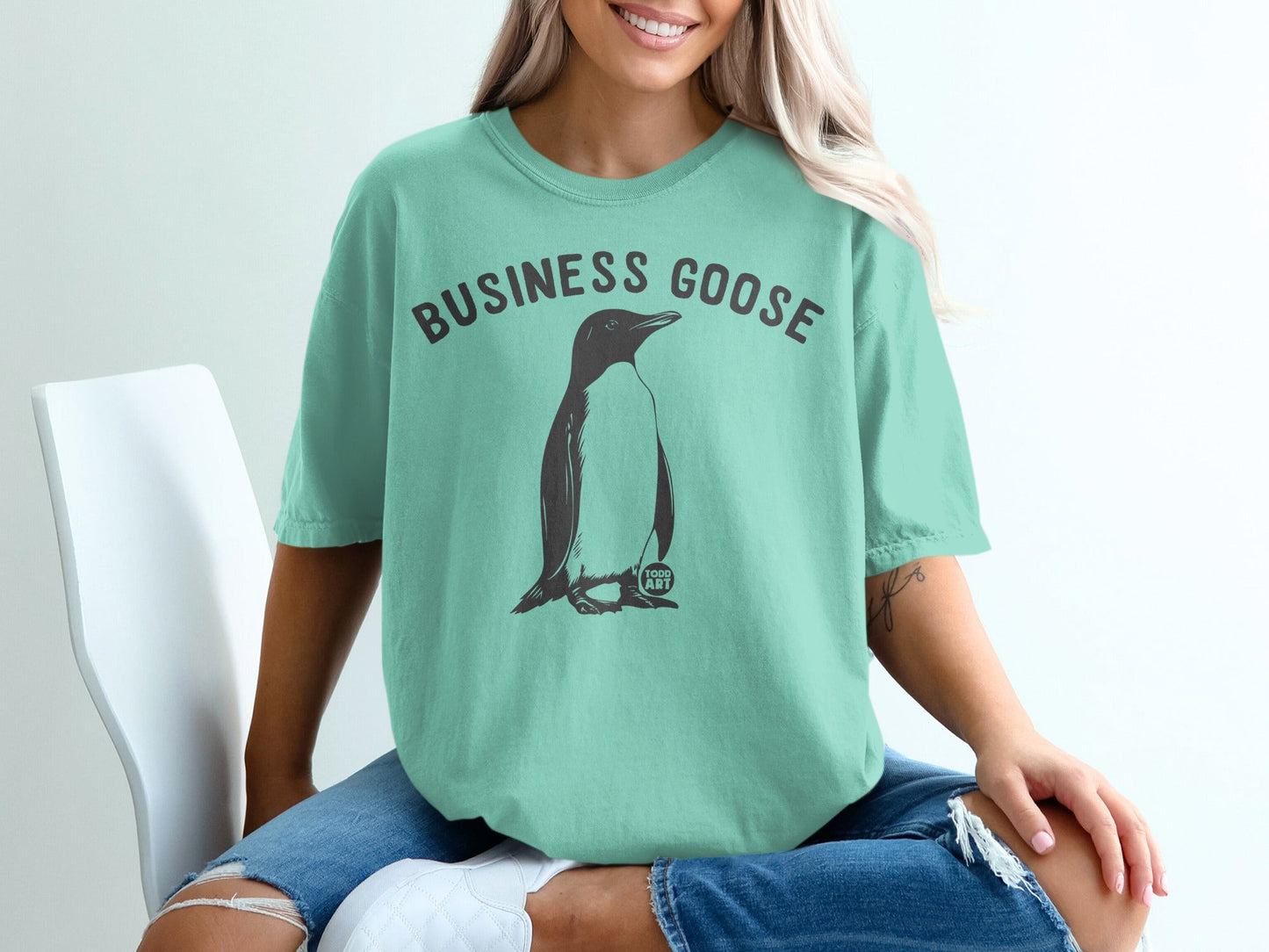 Teal t-shirt with a penguin graphic and "Business Goose" text.