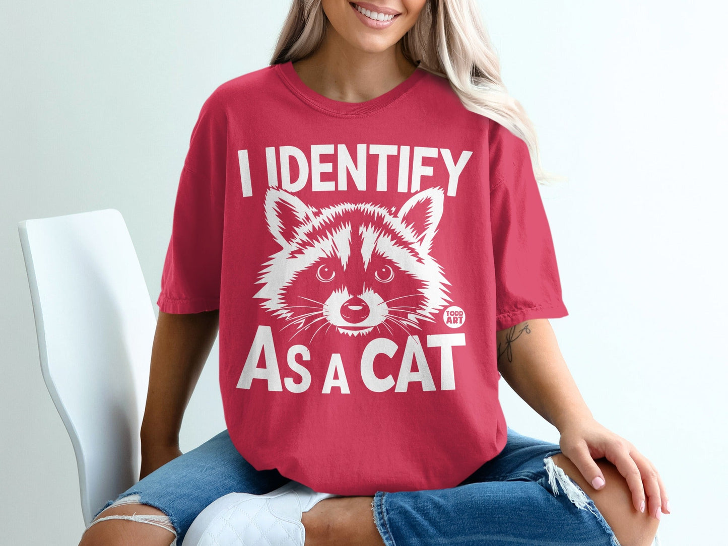 Red t-shirt with white "I IDENTIFY AS A CAT" graphic and raccoon face.