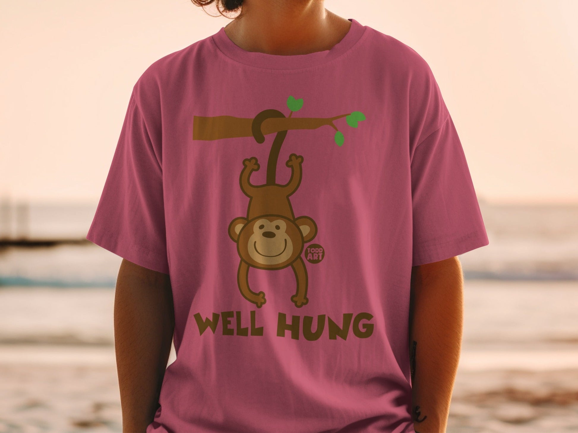 T-shirt with cartoon monkey hanging from a branch, text "WELL HUNG" and "TODD ART".