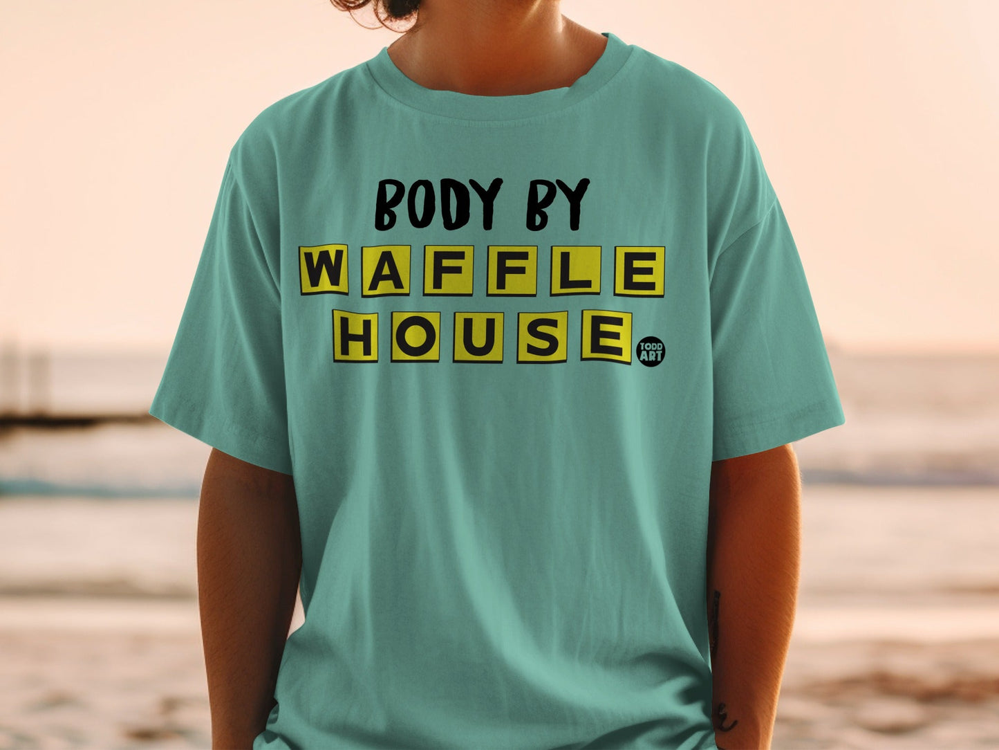 Teal t-shirt with "Body by Waffle House" text in yellow and black blocks.