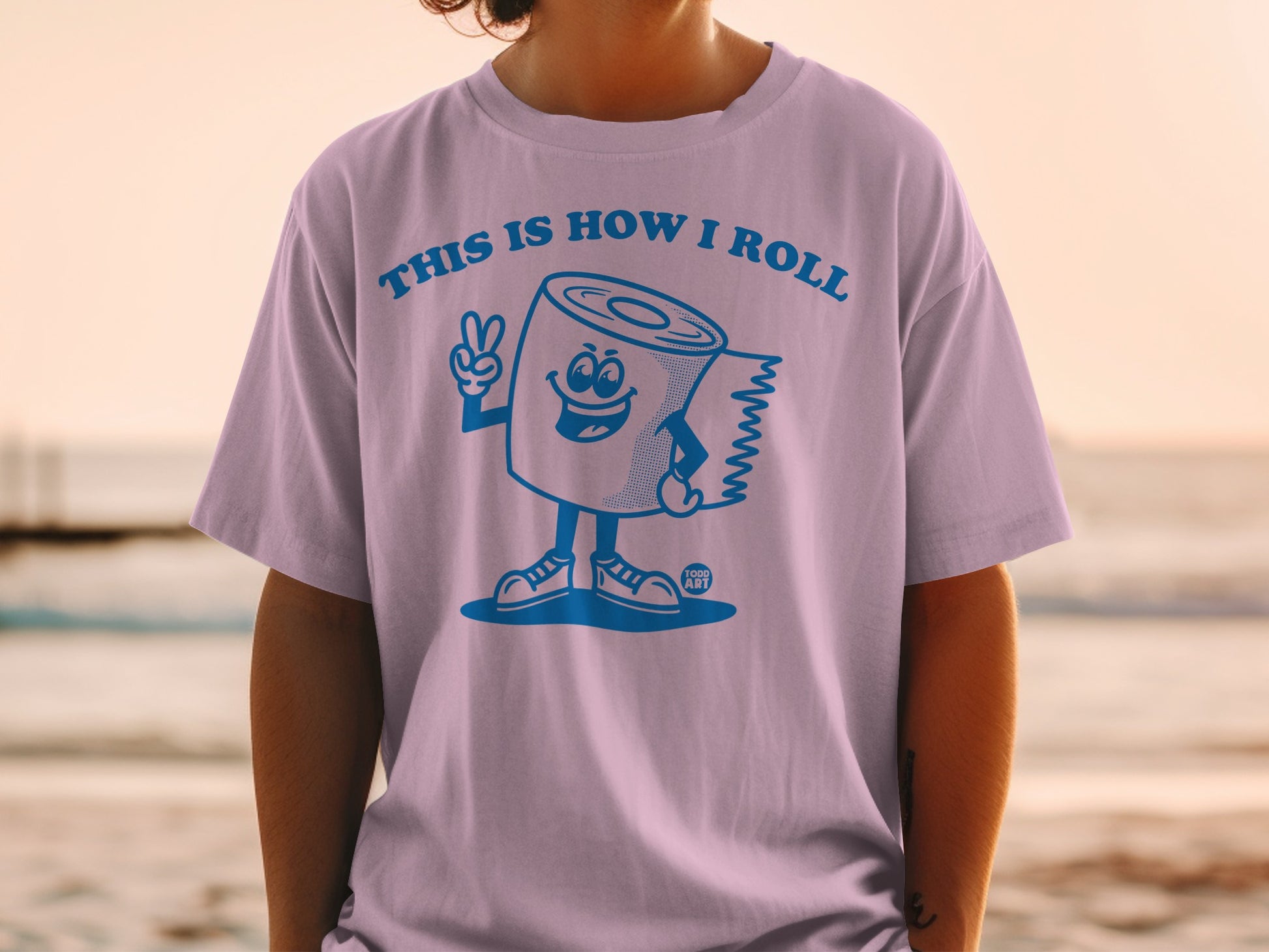 Light purple t-shirt with a cartoon toilet paper roll giving a peace sign.