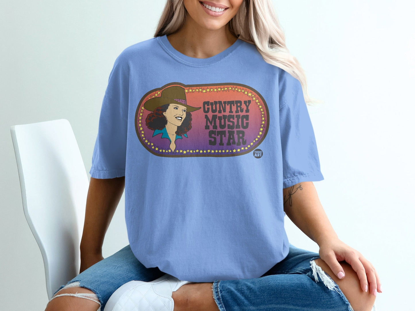 Blue t-shirt featuring a woman in a cowboy hat and "Guntry Music Star" text.