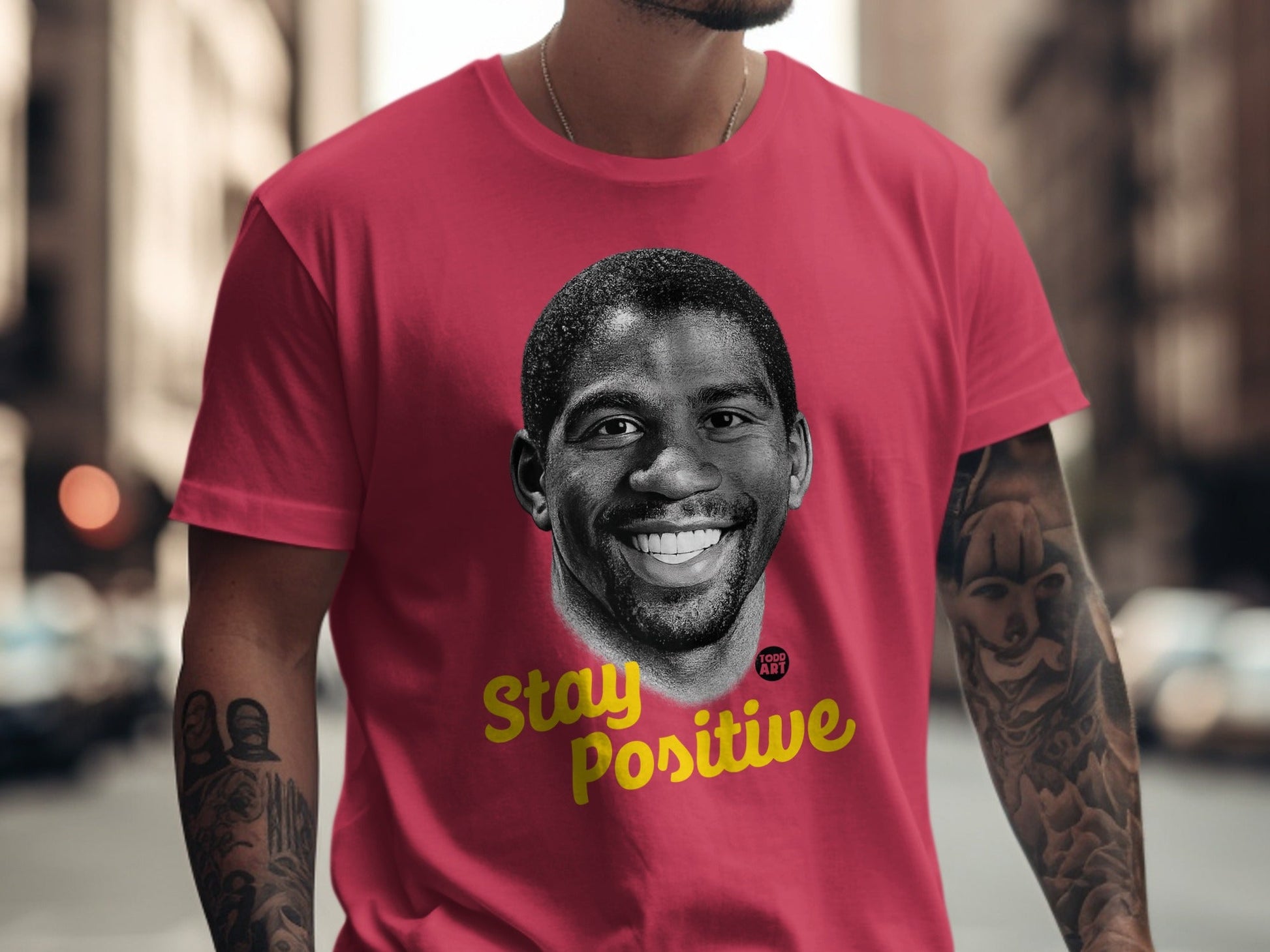 Red t-shirt with Magic Johnson's portrait and "Stay Positive" text.