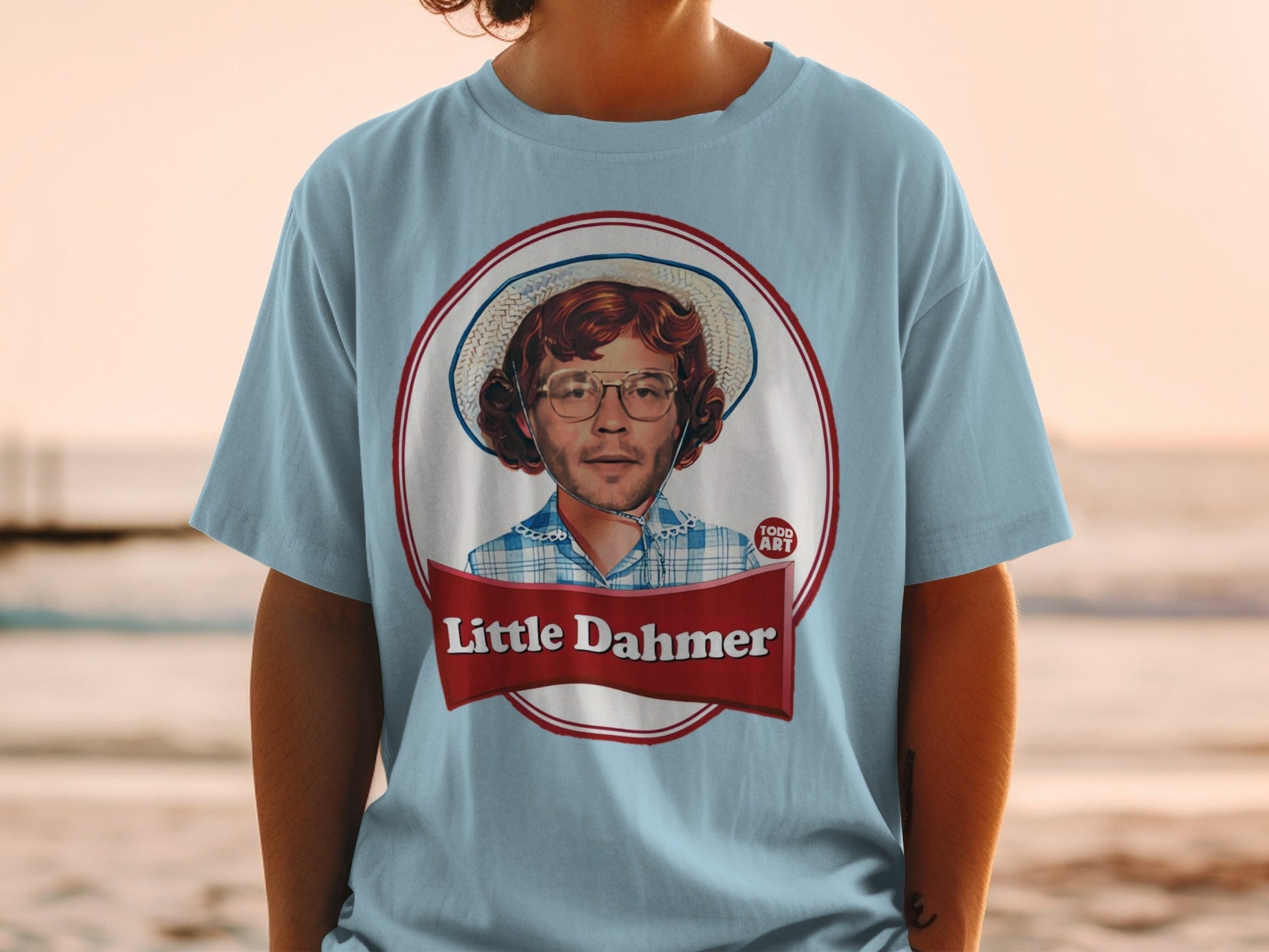 Light blue t-shirt with "Little Dahmer" graphic featuring a man in a straw hat.