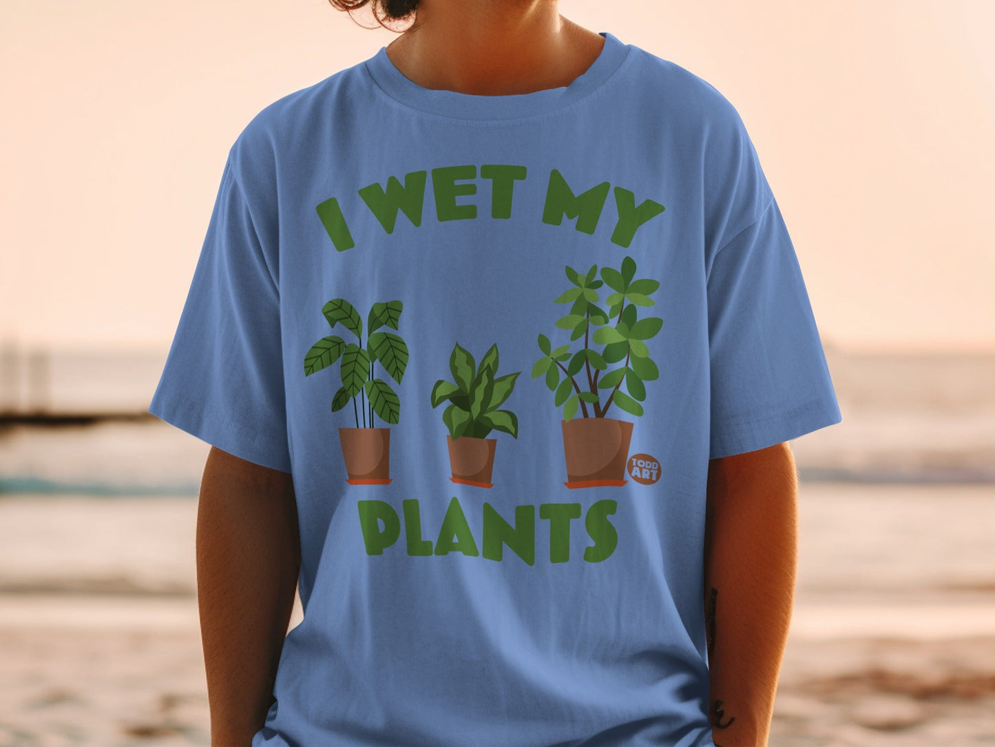 Blue t-shirt with "I WET MY PLANTS" and three potted plants.