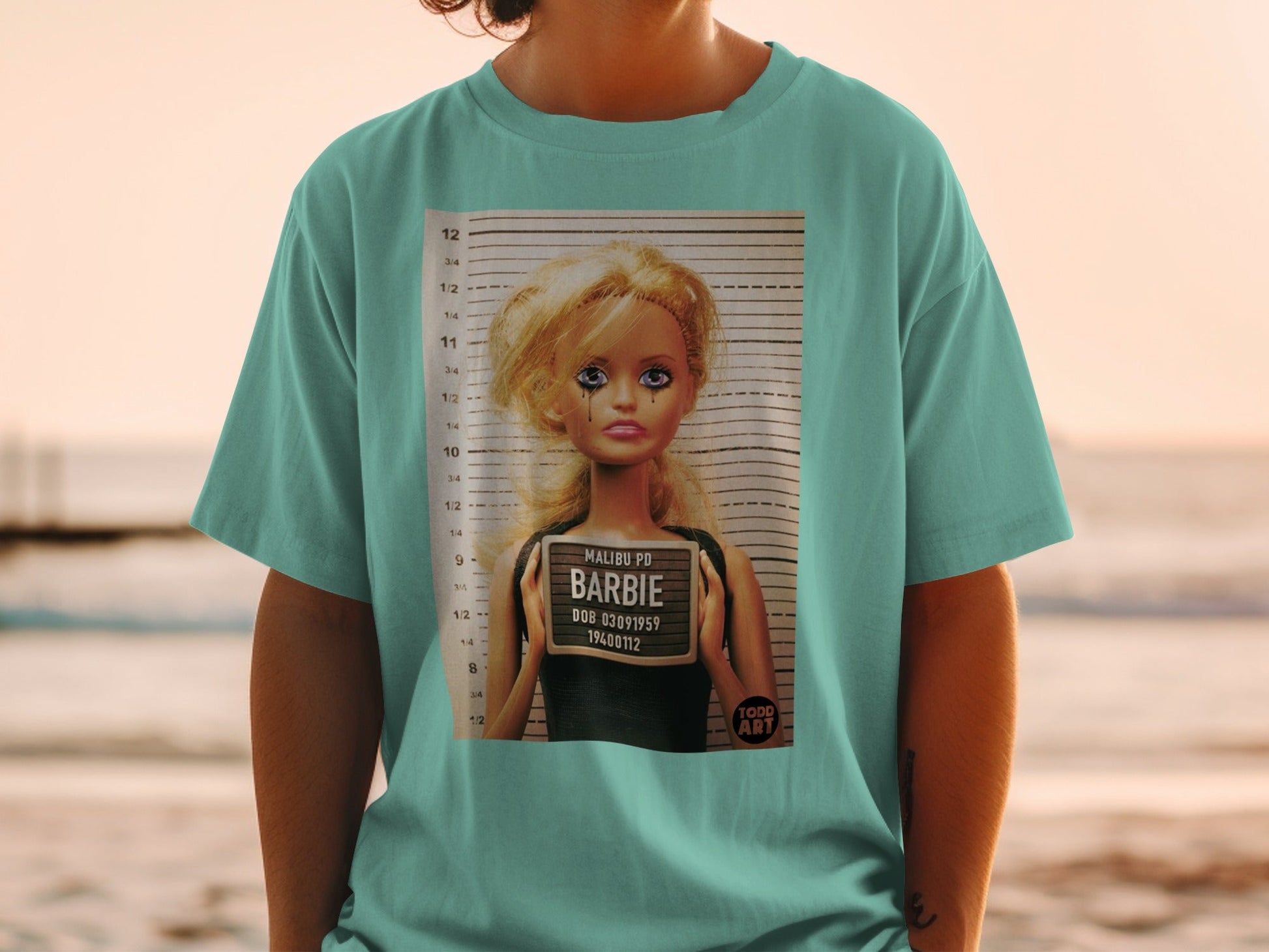 Barbie mugshot tee with Malibu PD, DOB, and Todd Art logo.
