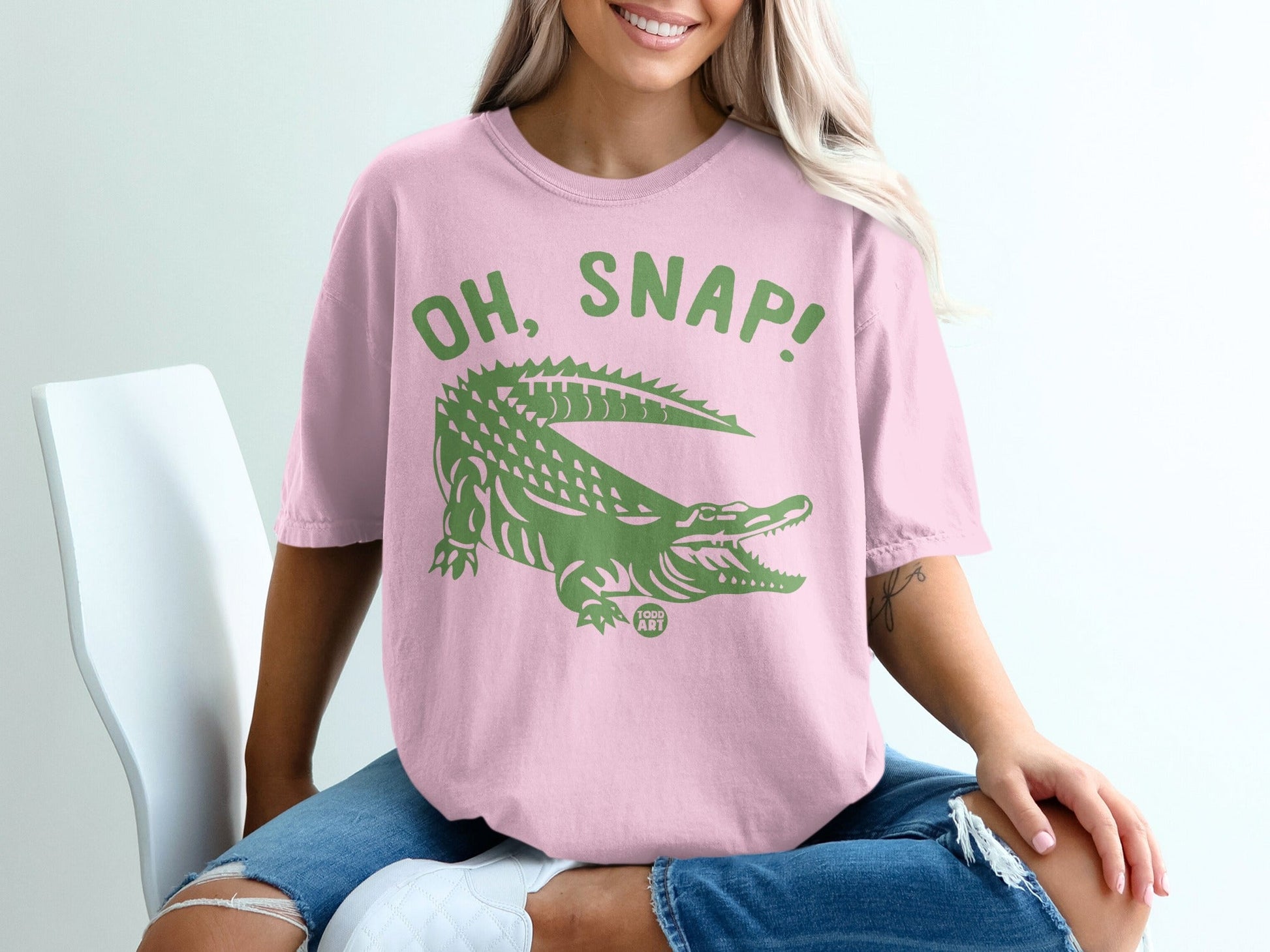 Pink t-shirt with green alligator graphic and "OH, SNAP!" text.