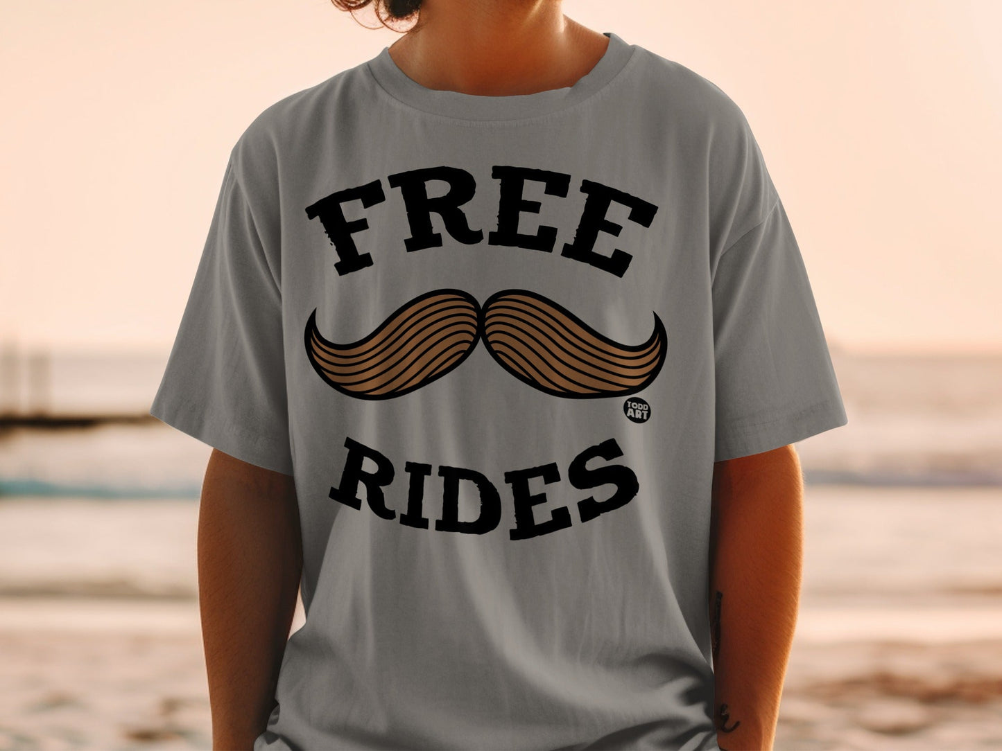 Grey t-shirt with "FREE" above a mustache graphic and "RIDES" below.