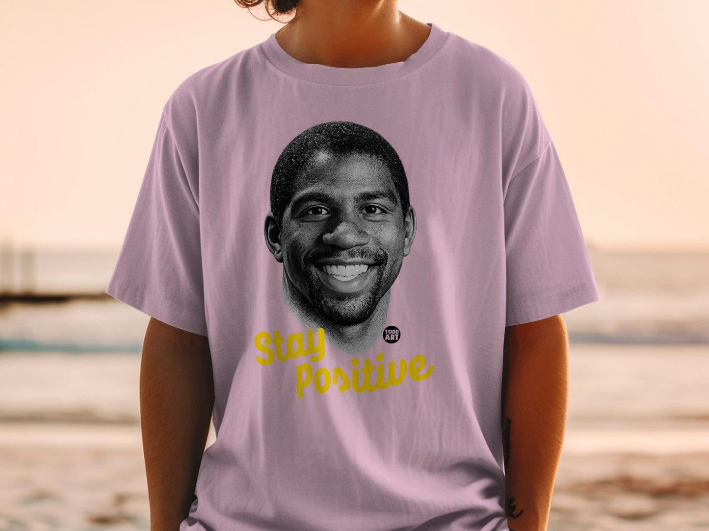 Magic Johnson portrait on a lilac t-shirt with "Stay Positive" text.