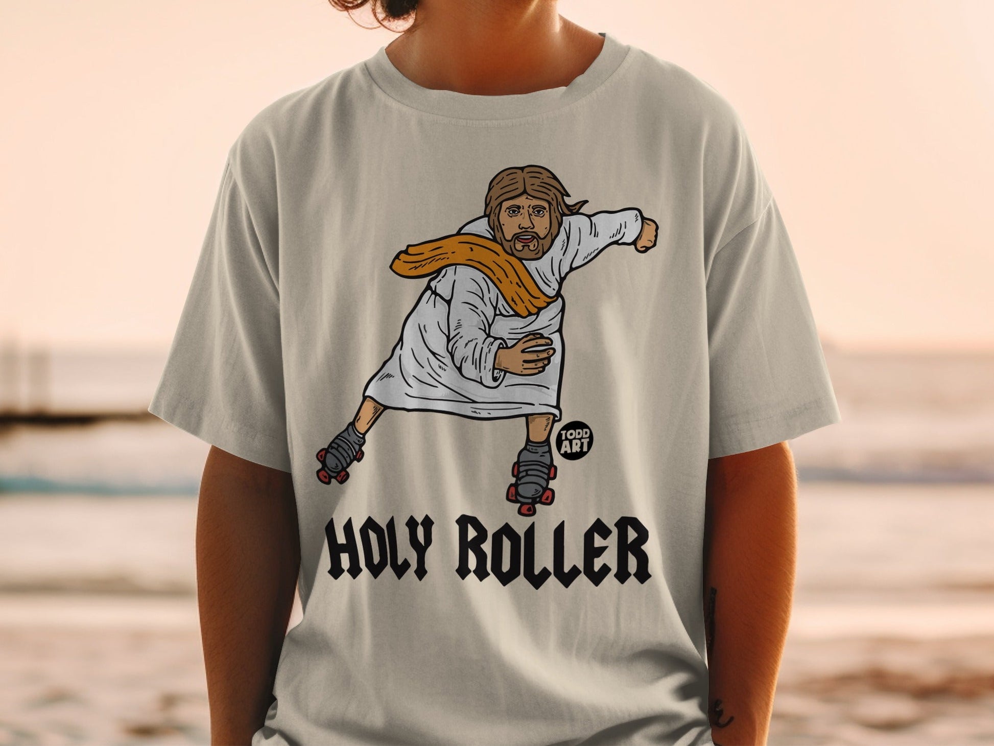 T-shirt graphic of Jesus on roller skates, text "Holy Roller".