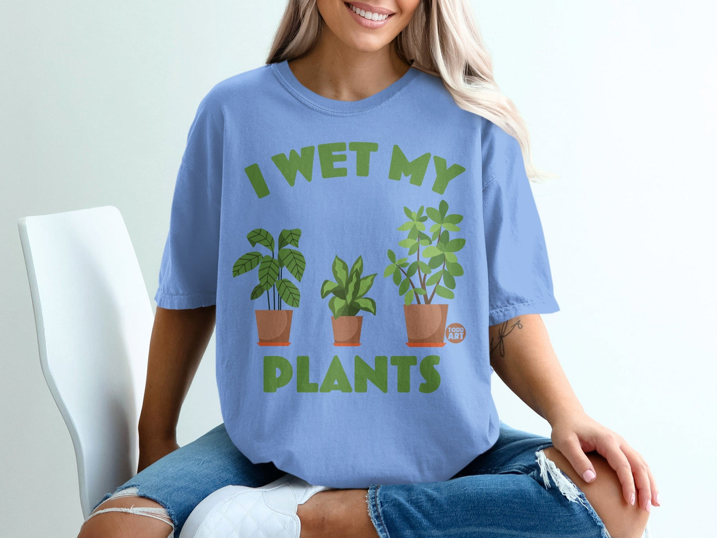 Light blue t-shirt with green text and plant illustrations.