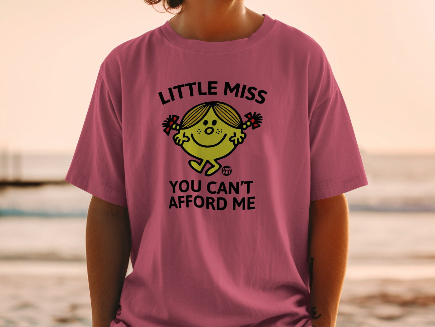 Pink t-shirt with "Little Miss You Can't Afford Me" cartoon character design.