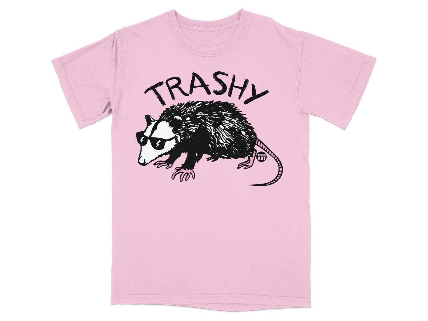 Pink t-shirt with black graphic of a raccoon wearing sunglasses and text "TRASHY".