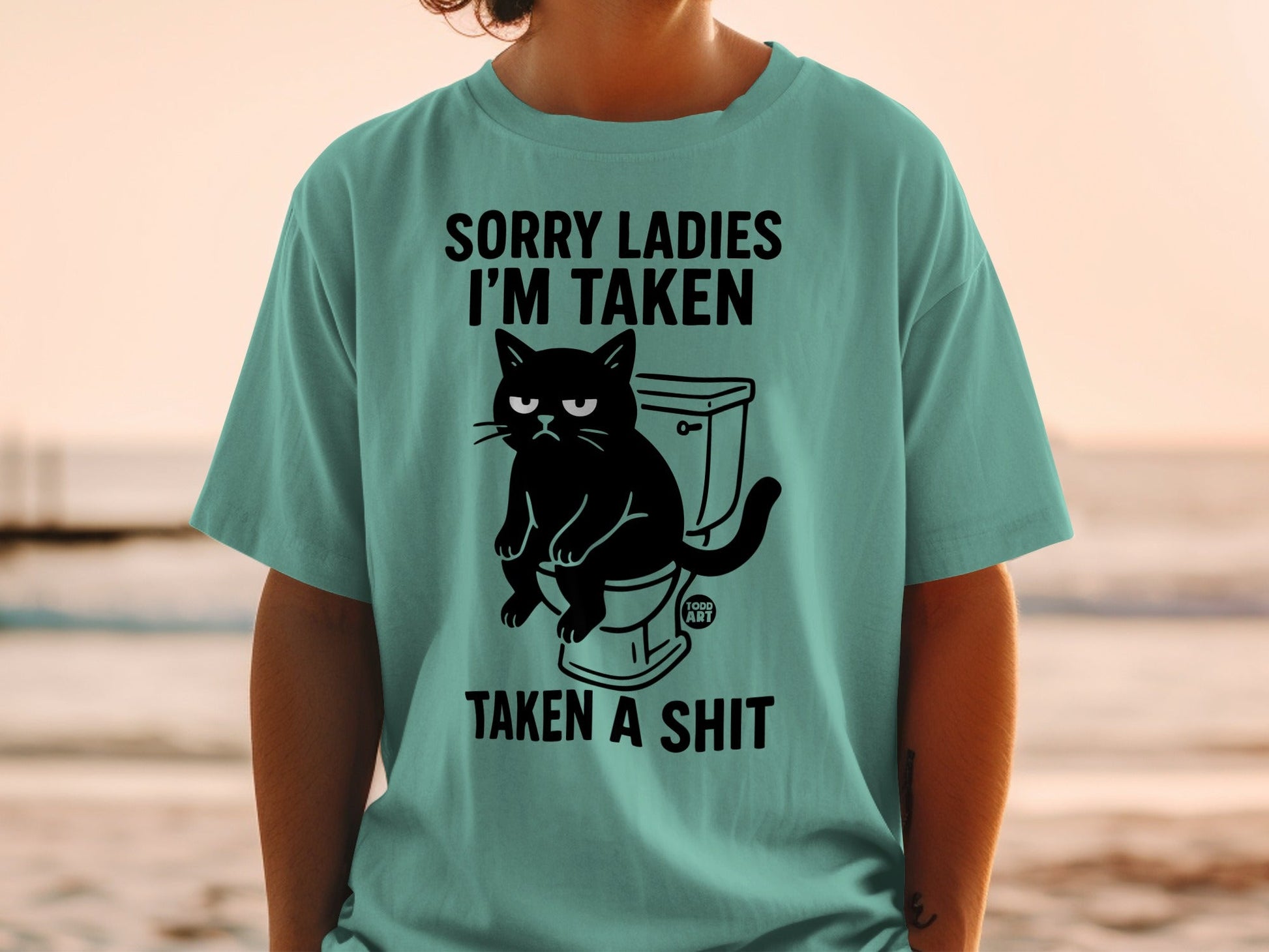 T-shirt with a black cat on a toilet and text "Sorry ladies I'm taken taken a shit".