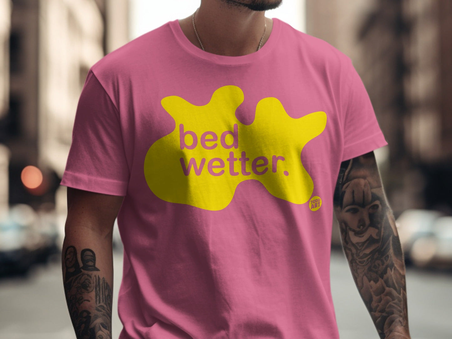 Pink t-shirt with yellow "bed wetter." logo and small "too lit" text.