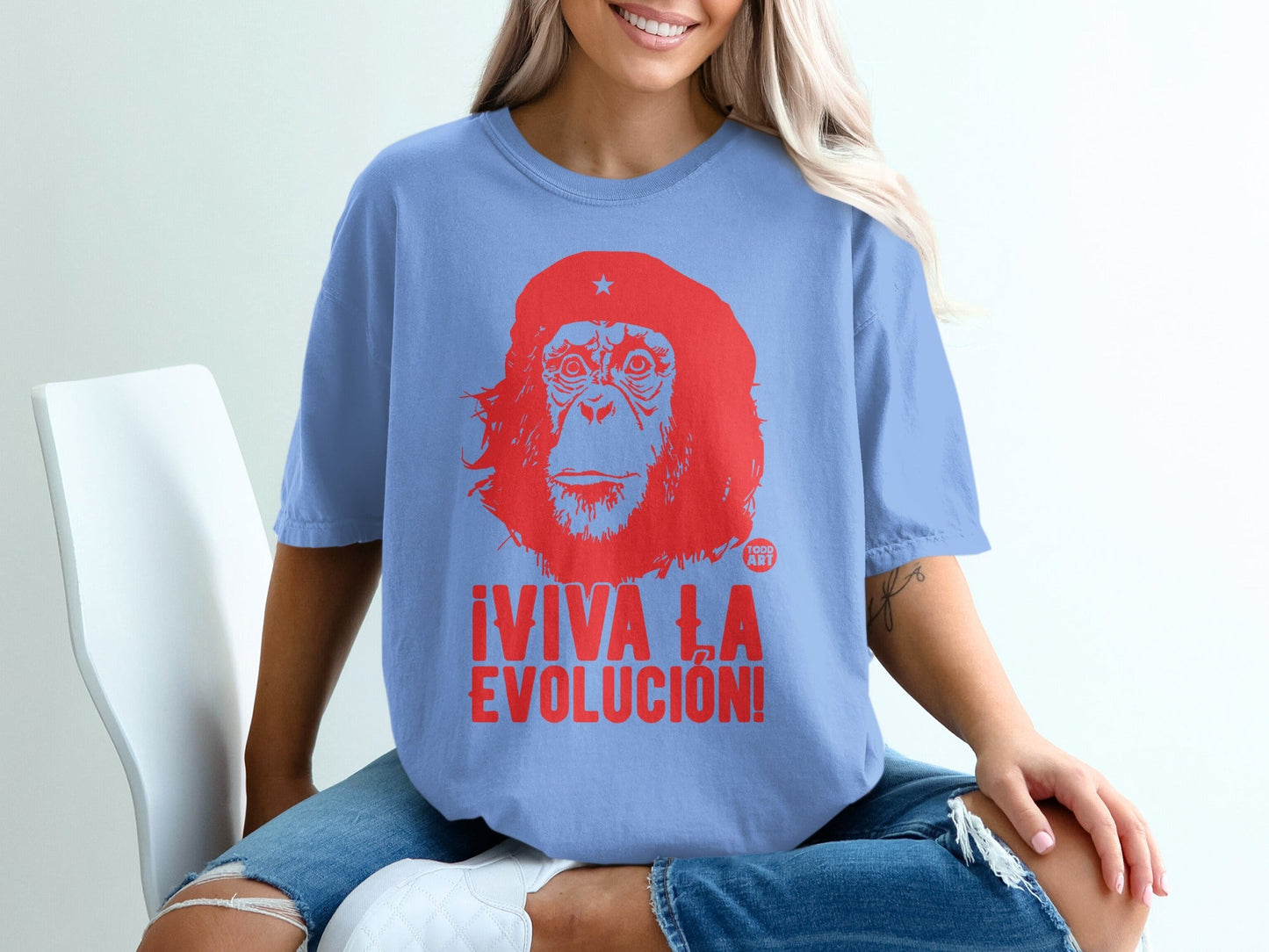 Light blue t-shirt with red graphic of Che Guevara and text "¬°VIVA LA EVOLUCI√ìN!".