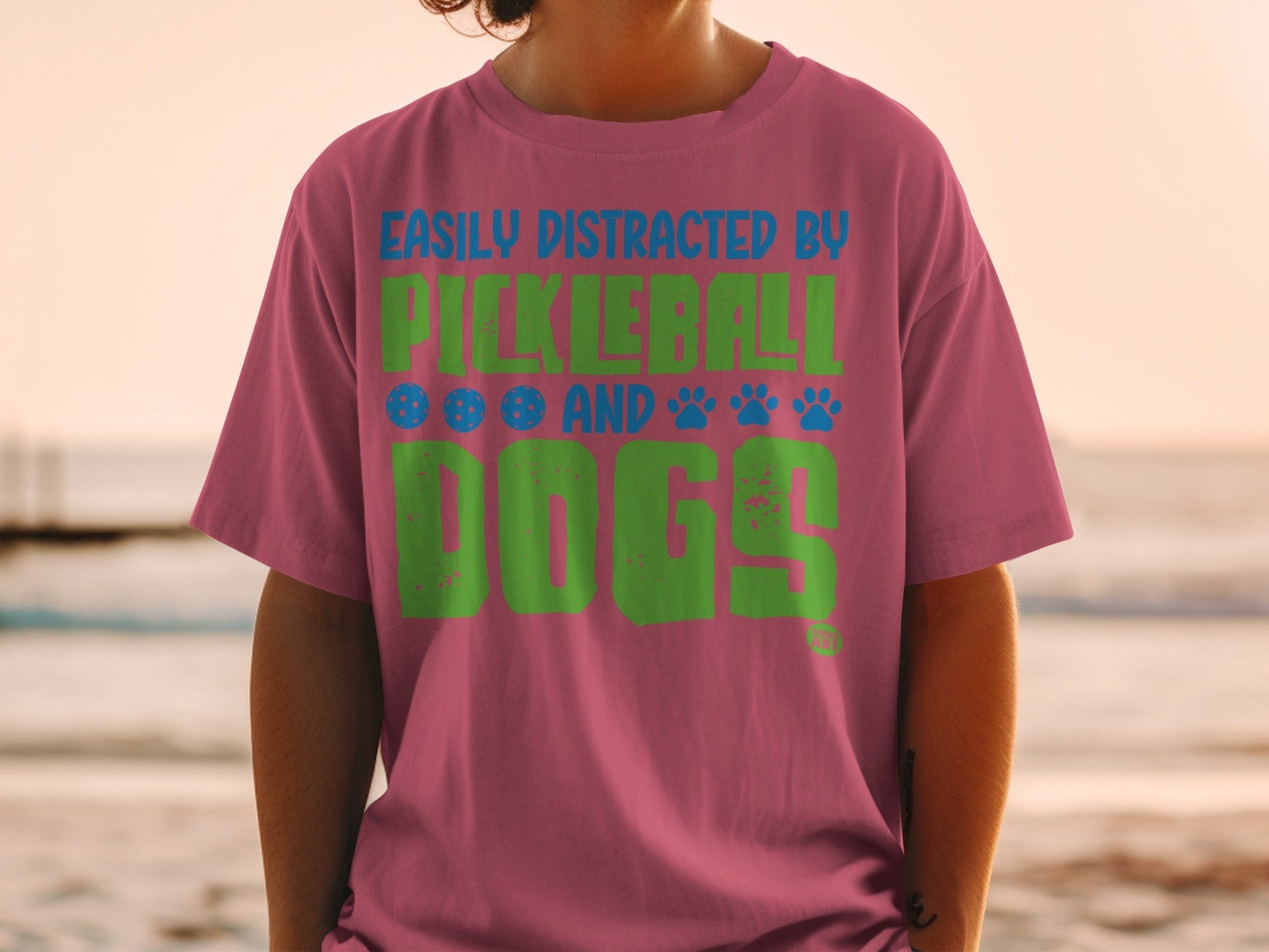 Pink t-shirt with "Easily Distracted by Pickleball and Dogs" text.