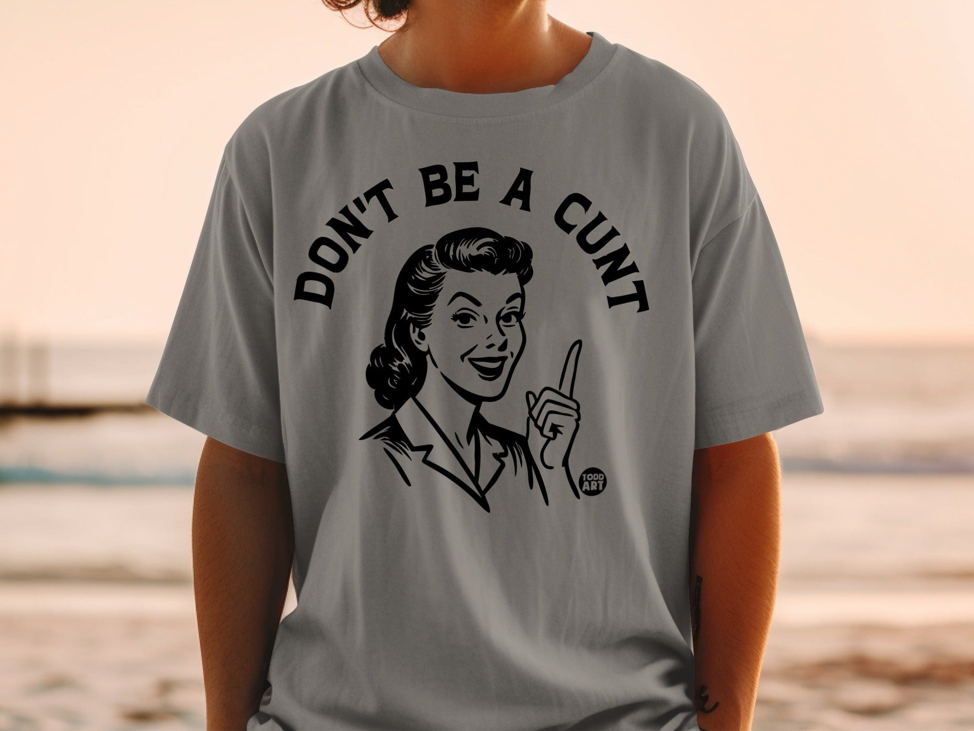 Grey t-shirt with a graphic of a woman saying "DON'T BE A CUNT".