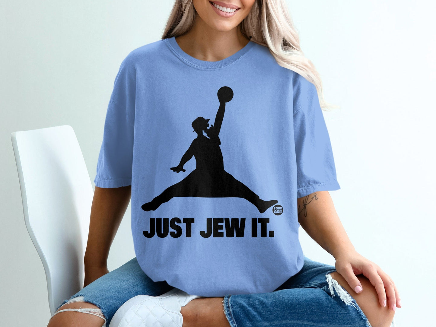 T-shirt featuring a silhouette of a jumping man in a hat, holding a ball, with "JUST JEW IT." text.