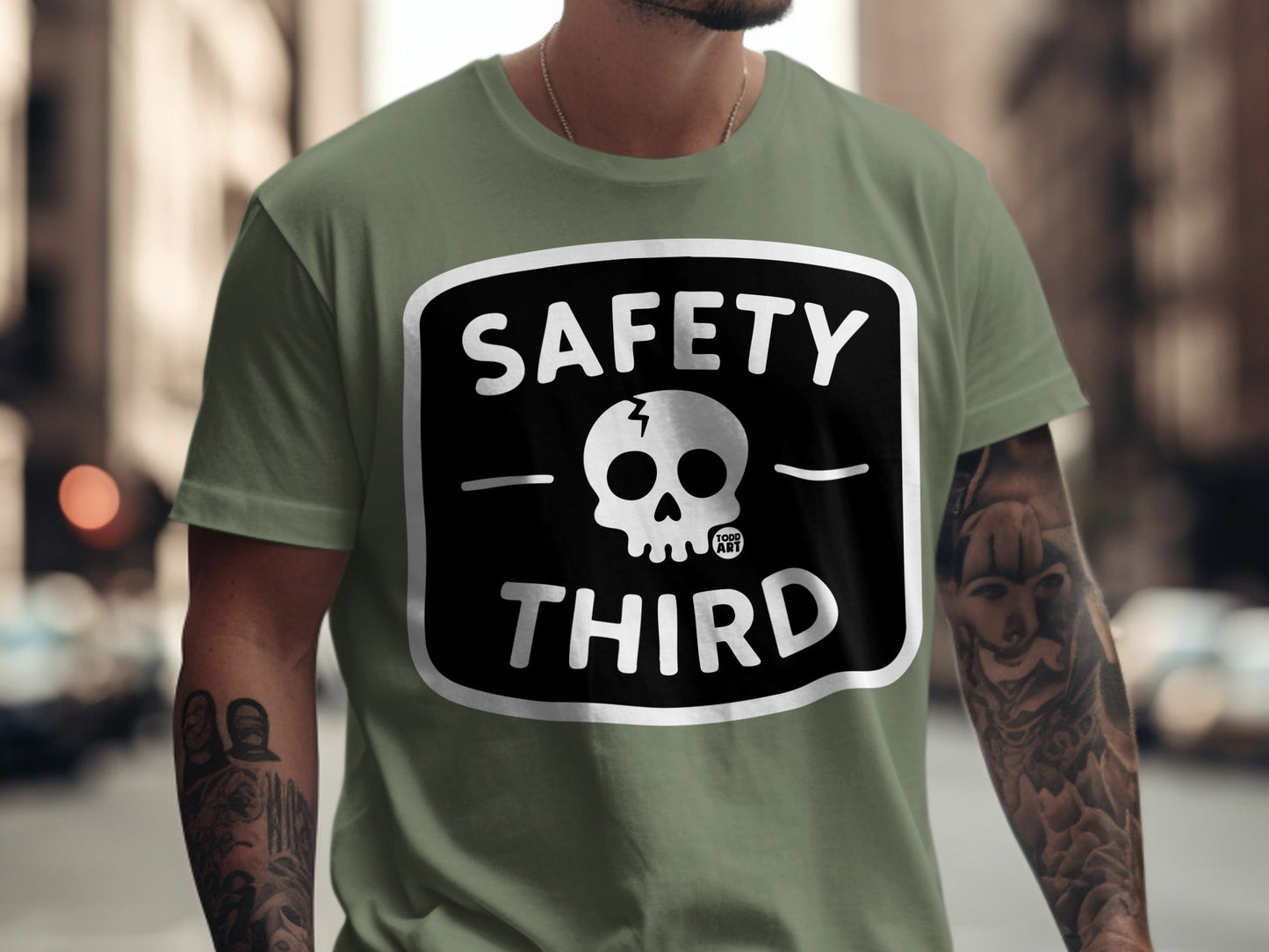 Olive green t-shirt with black "SAFETY THIRD" text and skull graphic.