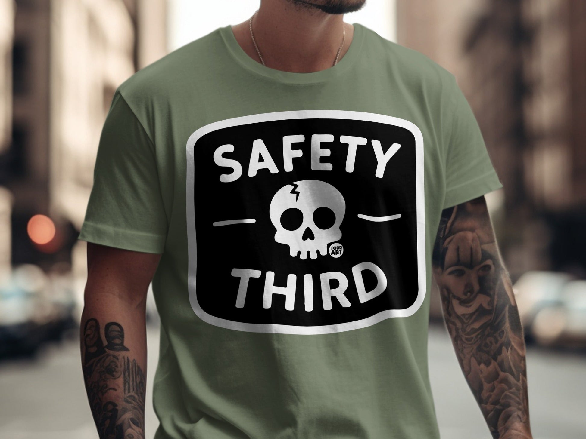 Olive green t-shirt with black "SAFETY THIRD" text and skull graphic.