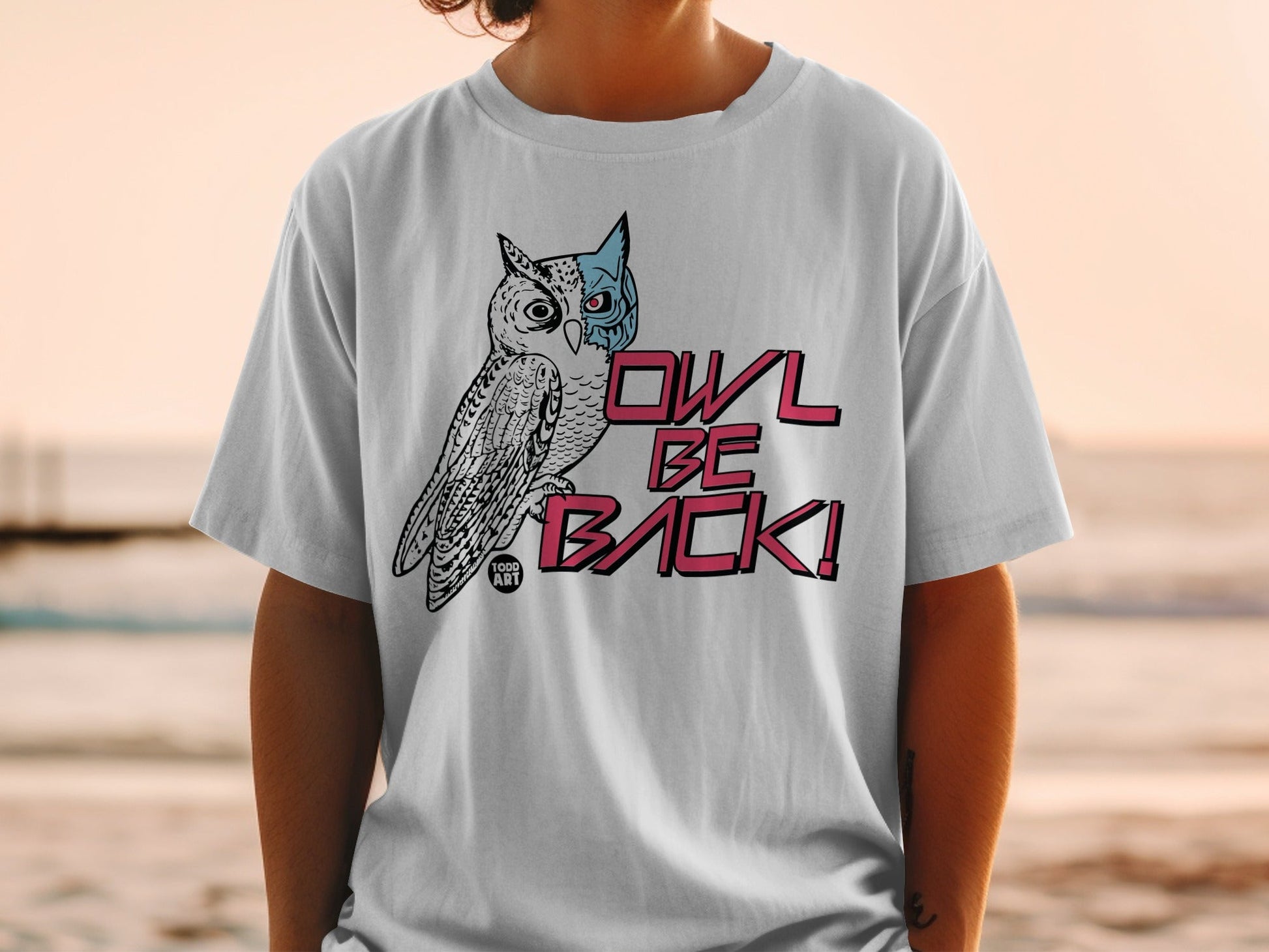 White t-shirt with a stylized owl graphic and "OWL BE BACK!" text.