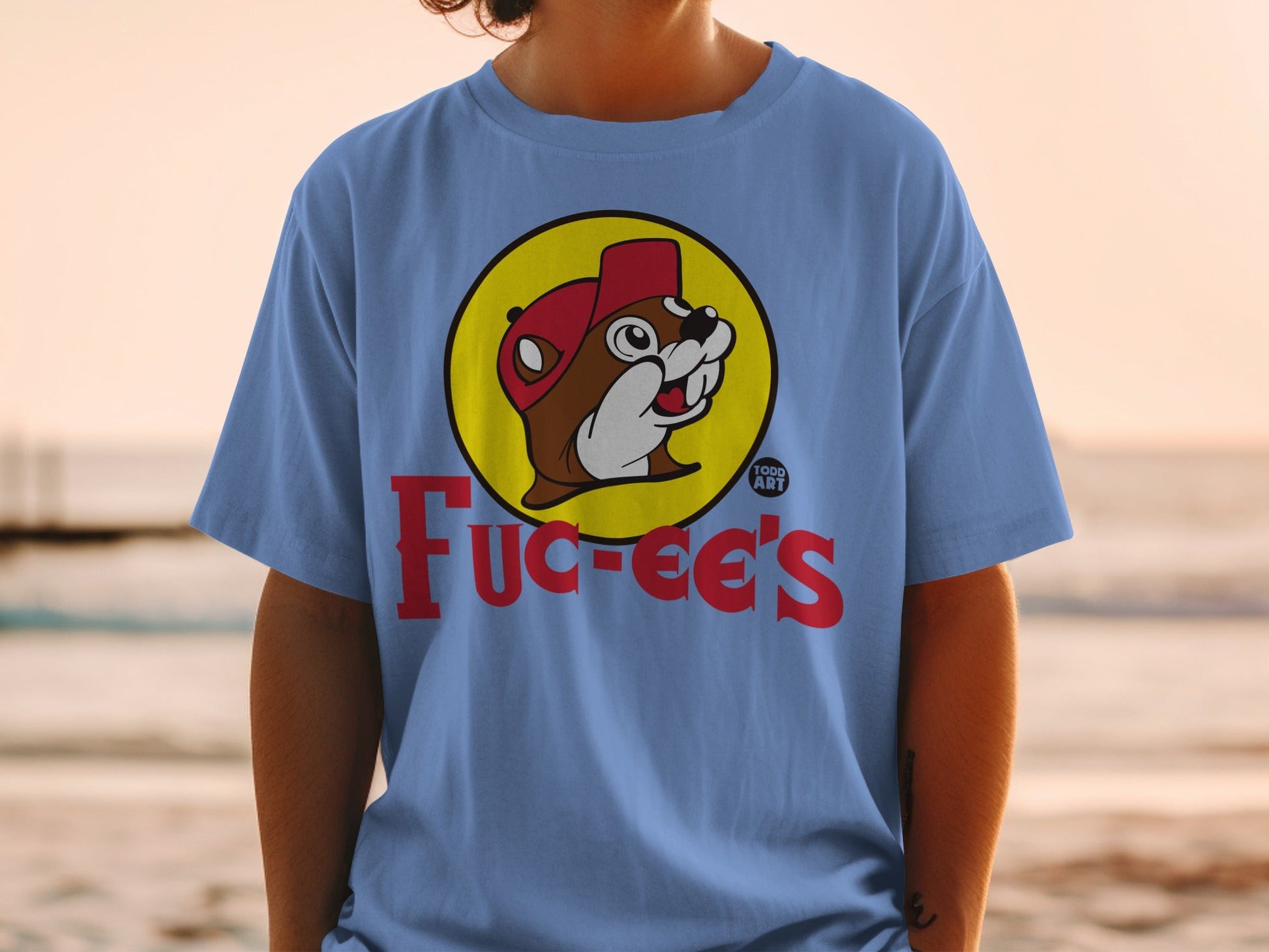 Buc-ee's logo on a light blue t-shirt worn by a person.